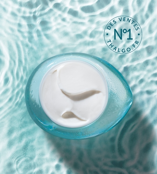 Texture crémeuse blanche du gel-crème vue de dessus dans son emballage bleu translucide avec badge n°1