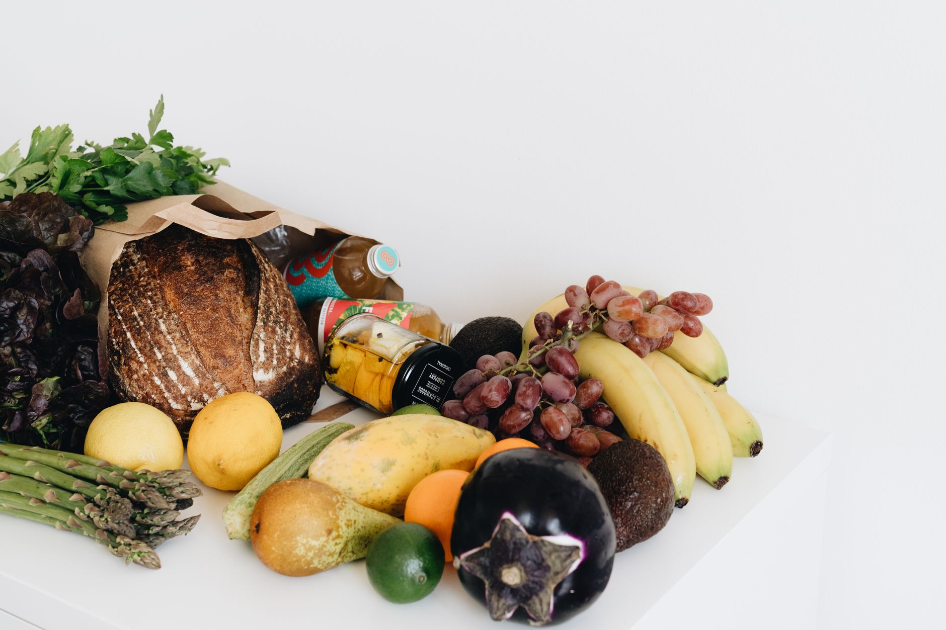 Assortiment de fruits et légumes frais avec pain complet, bananes, raisins, poires, citrons, asperges et autres produits d'épicerie