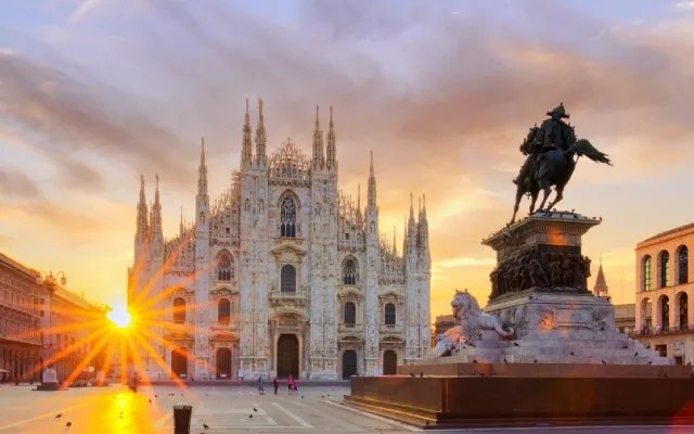 Mailänder Dom mit Reiterdenkmal und Sonnenstrahlen auf der Piazza bei Sonnenaufgang