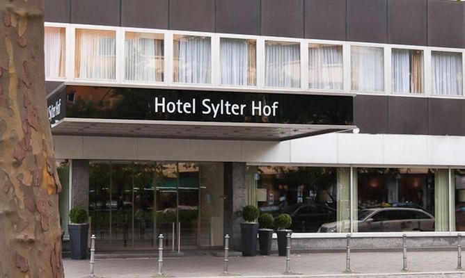 Hoteleingang mit schwarzem Schild und modernem Fassadendesign in urbaner Umgebung
